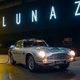 A silver Aston Martin DB6 plugged in to charge